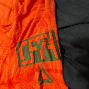 Two pair of workout shirts. One is Reebok crossfit the other is Under Armor.